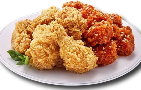 A white plate featuring a combination of golden-brown crispy fried chicken and red spicy glazed seasoned chicken garnished with crushed nuts.